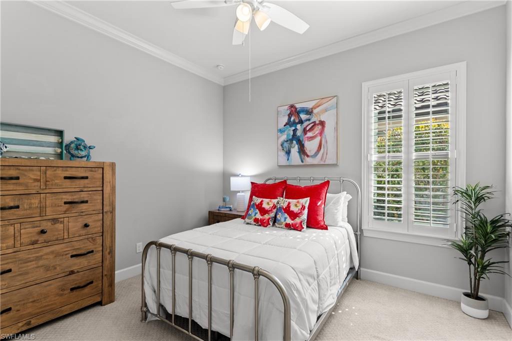 Crown molding accentuating light gray walls, with a white ceiling fan and recessed lighting