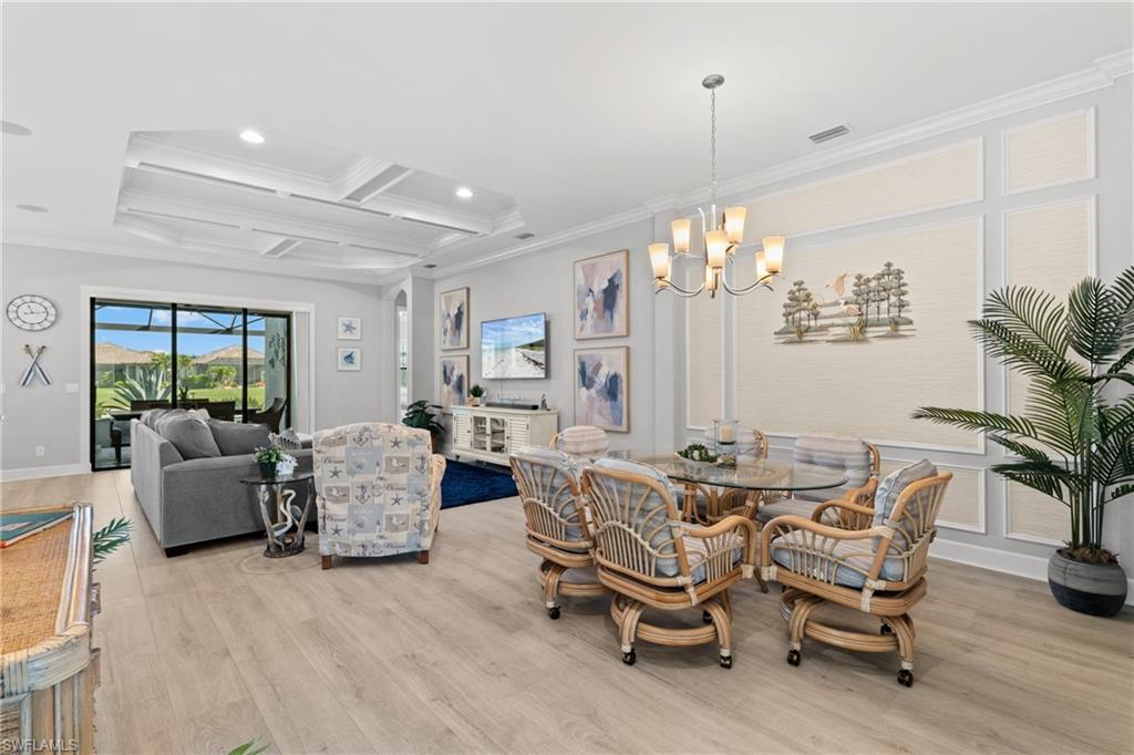 Expansive living area with wood-finish flooring, a coffered ceiling, and a chandelier