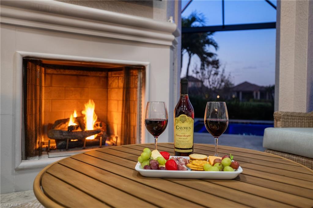Outdoor fireplace with a stone surround, a screened enclosure, and a tiled hearth