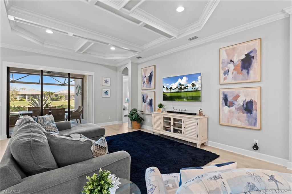 Tray ceiling with recessed lighting, wood-finish flooring, and sliding glass doors opening to a screened outdoor area