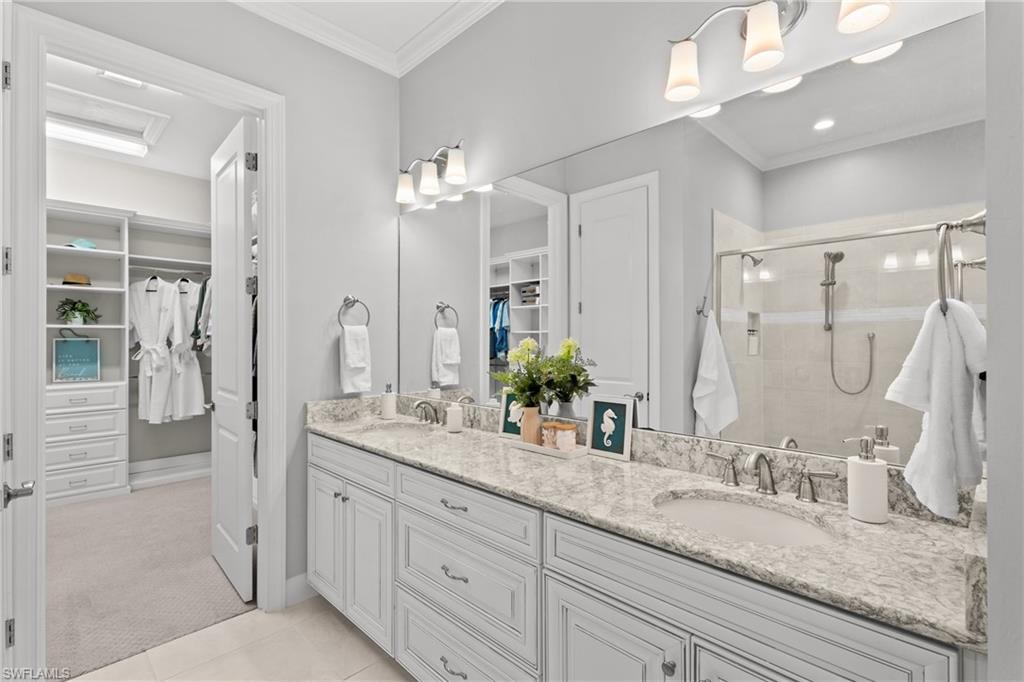 Double vanity with undermount sinks, stone countertop, and individual vanity lighting