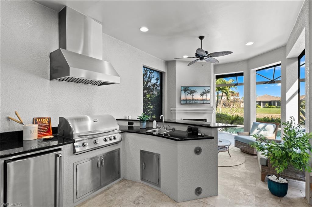 Outdoor kitchen with gas grill, fridge and granite counters