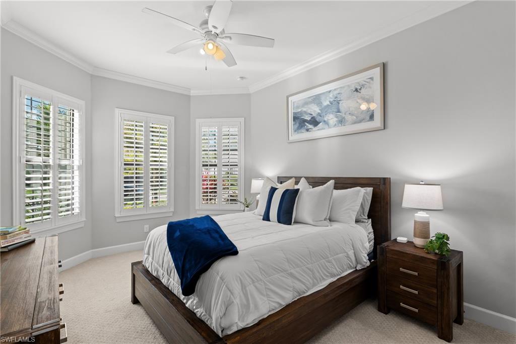 Bay window with plantation shutters, ceiling fan with integrated lighting, recessed lighting, and crown molding