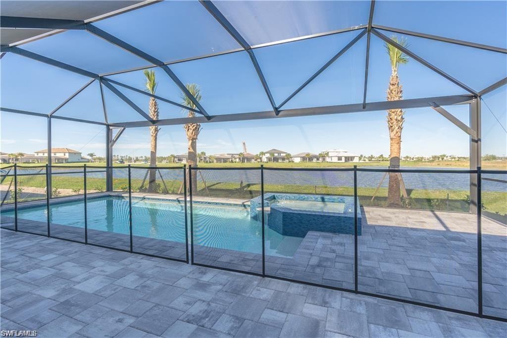 Screened-in outdoor living space with a pool, integrated spa with mosaic tile, and a surrounding paver patio
