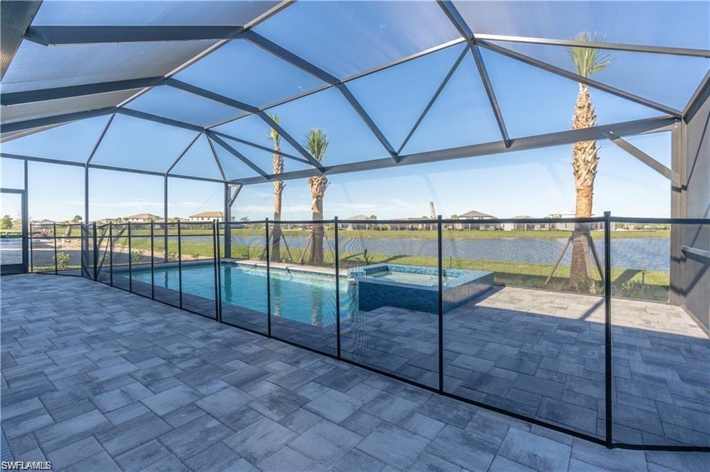Screened lanai featuring a swimming pool, integrated spa, and paver decking