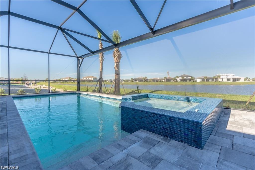 Screened-in outdoor living space featuring a swimming pool, integrated spa with blue mosaic tile, and paver patio