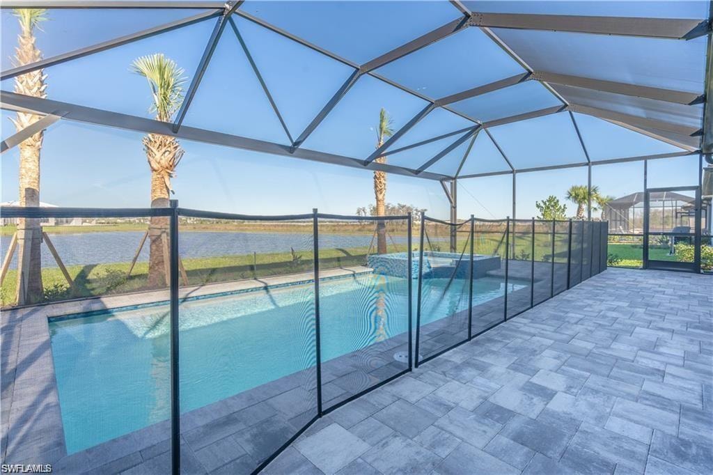 Screened lanai featuring a swimming pool, integrated spa, and paver decking