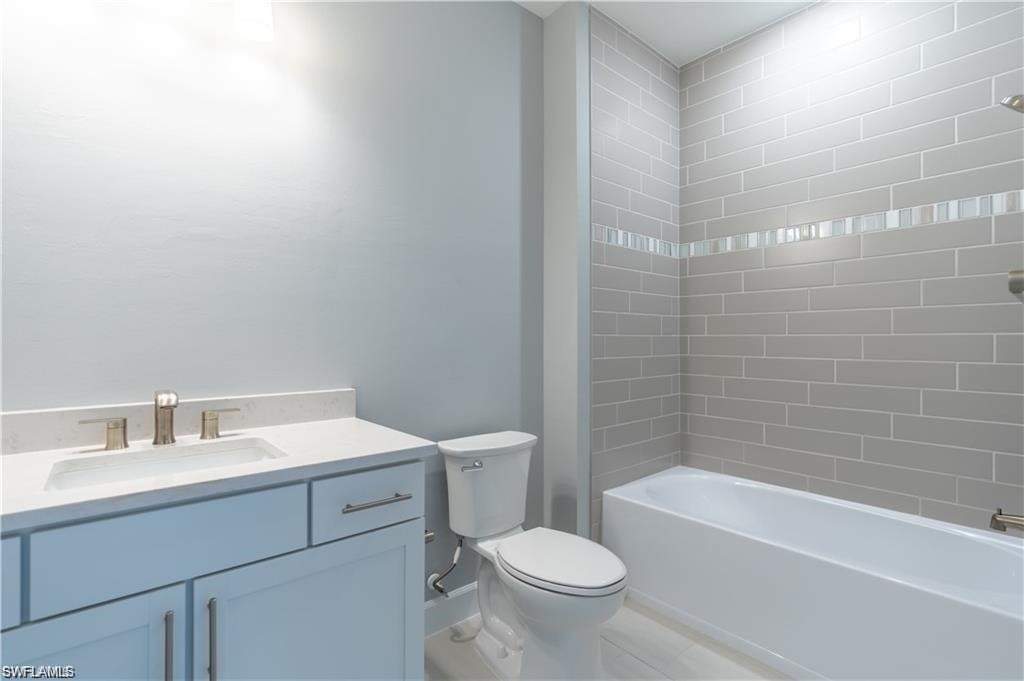 White vanity with a light-toned countertop and an undermount sink