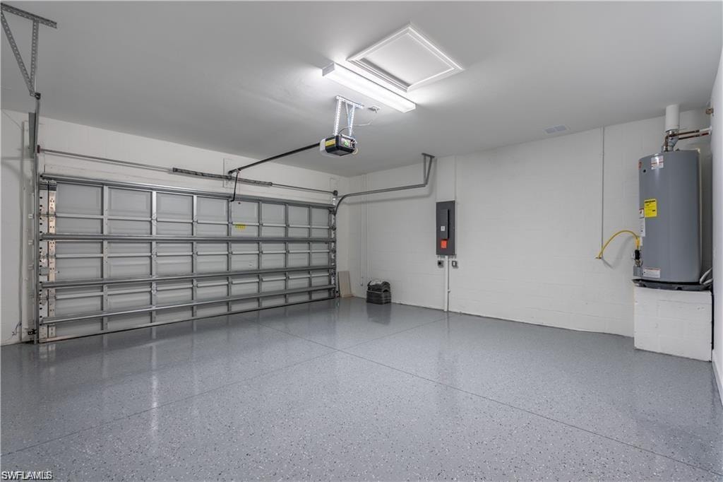 Attached garage featuring a sectional overhead door, automatic opener, epoxy-coated flooring, and a water heater