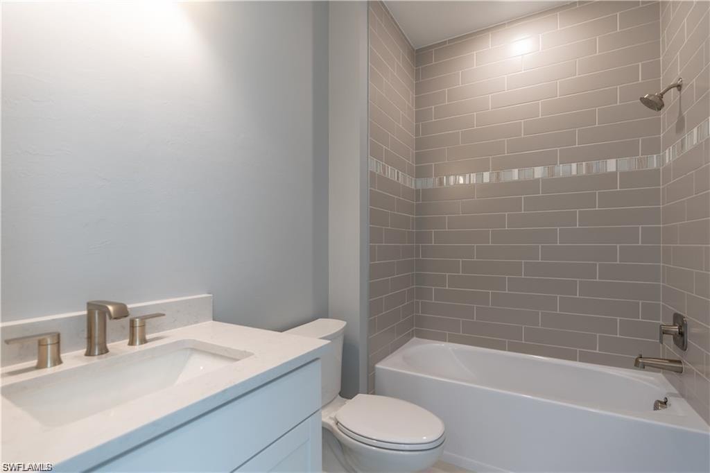 White vanity with an integrated rectangular sink, bronze-finish faucet, white countertop, and white toilet
