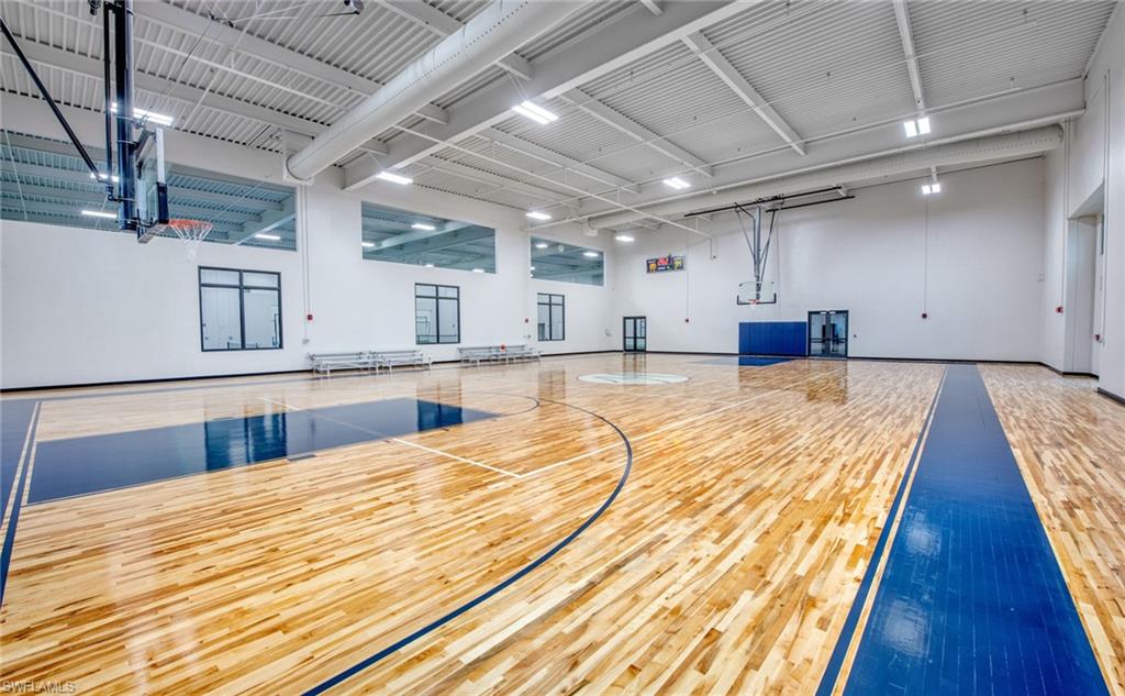 Indoor athletic court featuring wood-finish flooring with painted court lines and markings
