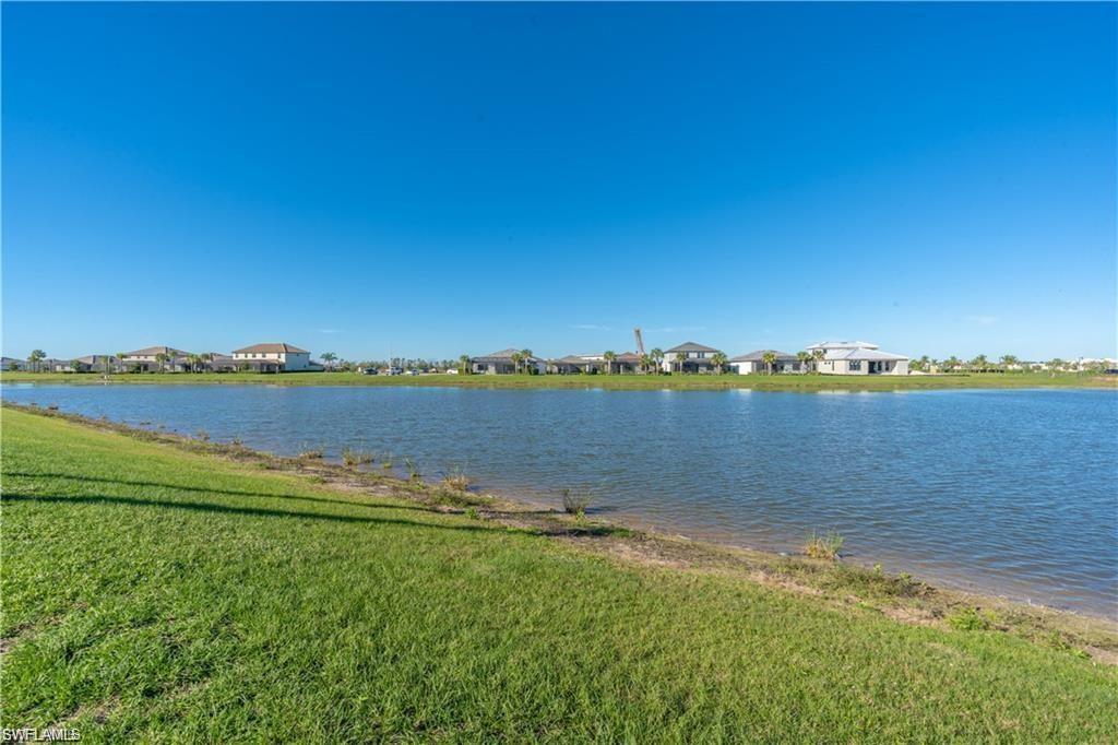 Expansive green space featuring a natural water body