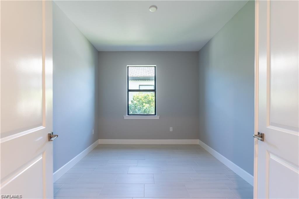 Recessed ceiling light, light-toned walls, white baseboards, window with dark trim, and light wood-finish flooring