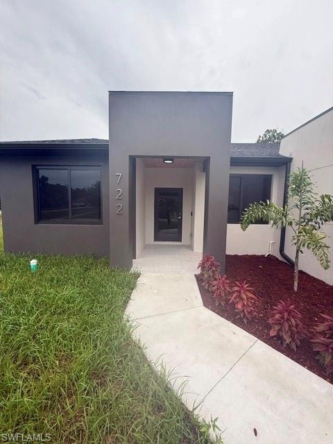 Contemporary exterior with a dark grey and light grey facade, a two-car garage, and an extended concrete driveway