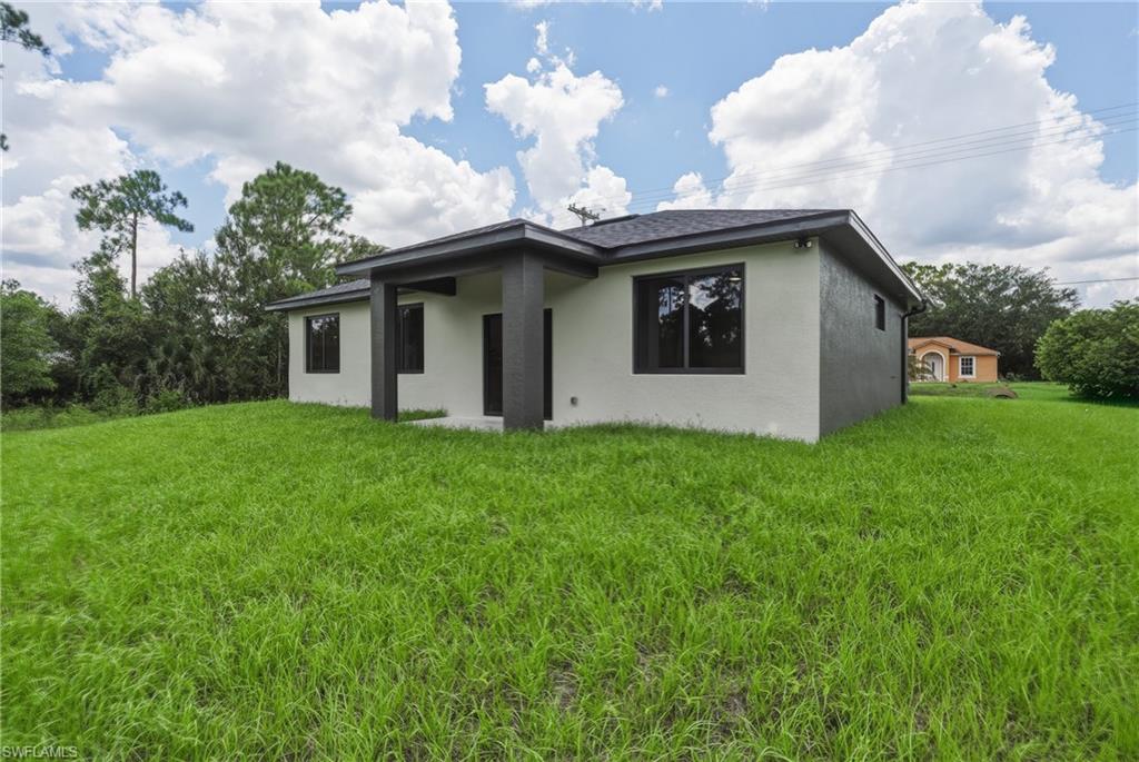 Modern exterior with a contrasting dark roof and light-colored stucco walls, featuring dark-framed windows and an integrated covered entry