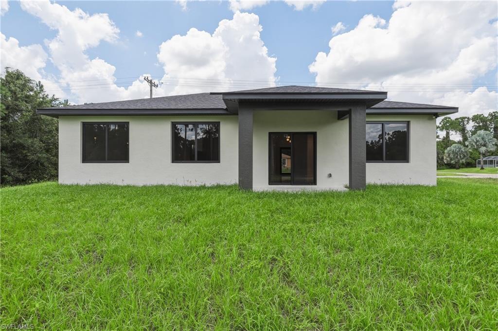 Contemporary exterior with a covered patio, flat roof, and expansive green space