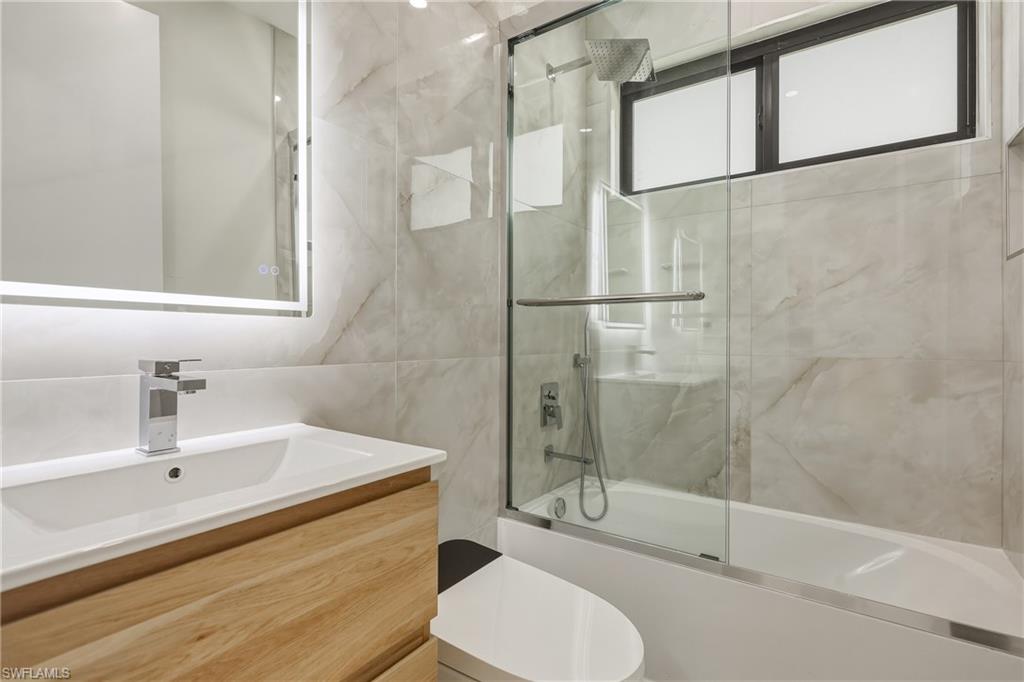 Light wood-finish vanity with an integrated sink and chrome faucet