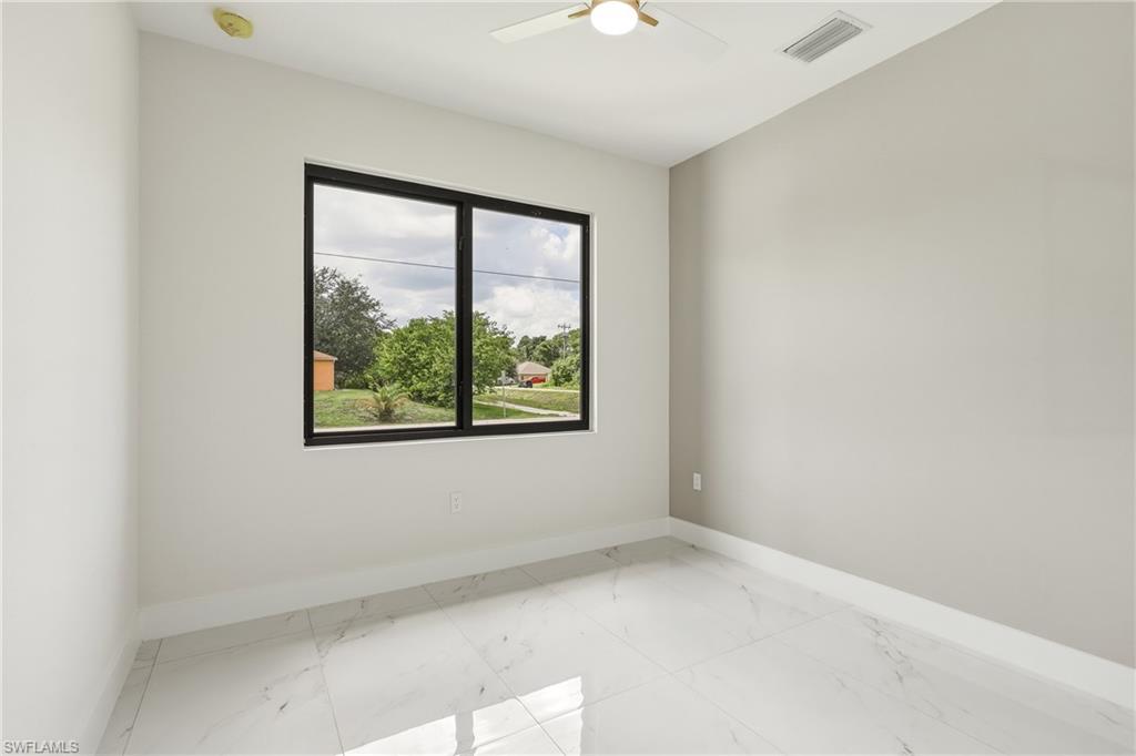 White tile flooring, black-framed window, ceiling fan, and recessed ceiling vent