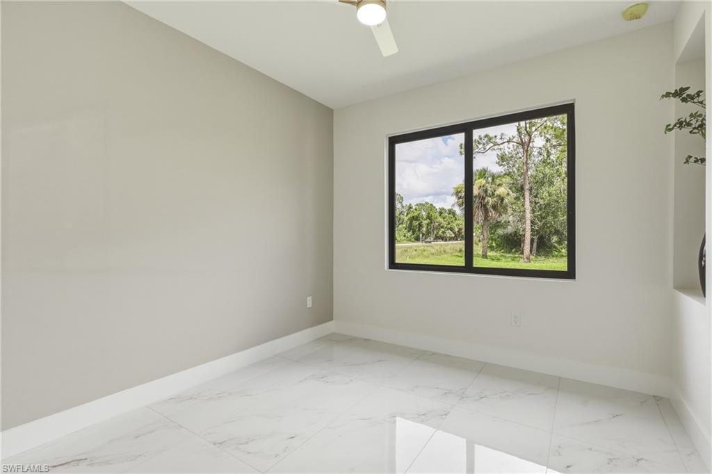 Porcelain tile flooring, recessed wall niche, contemporary ceiling fan, and large picture window