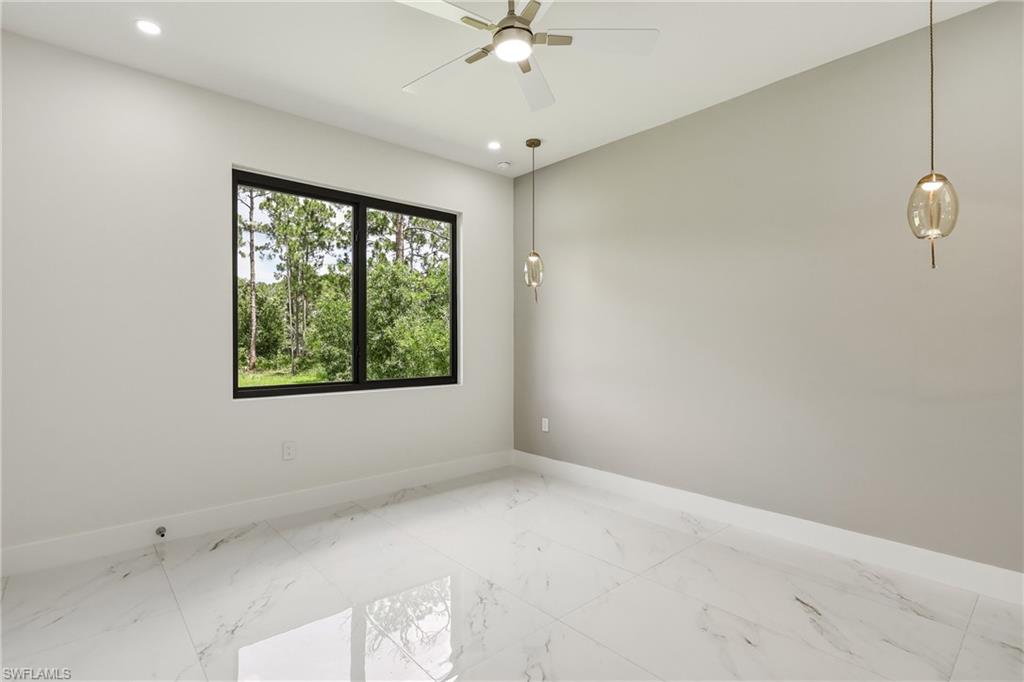 White porcelain tile flooring, a large black-framed window, recessed lighting, a ceiling fan, and pendant light fixtures