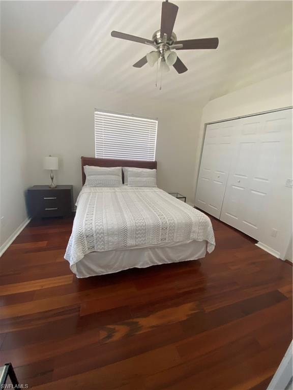Bedroom with ceiling fan, lofted ceiling, dark wood-type flooring, and a closet