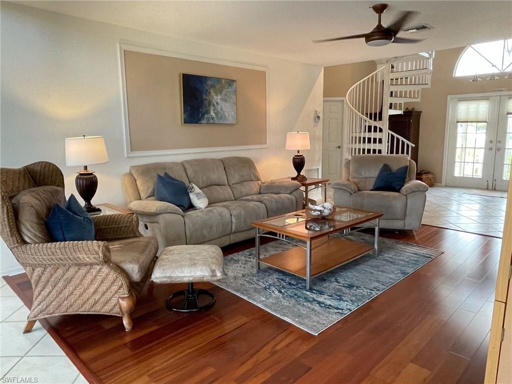 Tiled living room featuring a ceiling fan and french doors