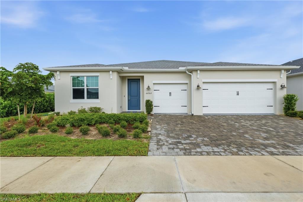 Attractive curb appeal with a paver driveway, three cr garage, manicured landscaping and a welcoming covered entry.