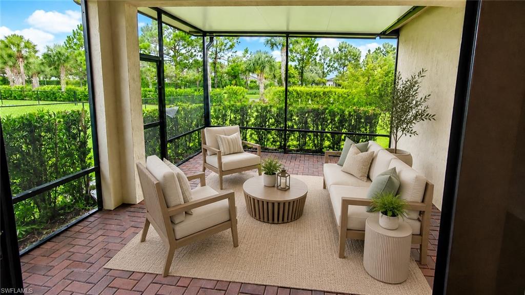 Screened outdoor living area with brick paver flooring and a textured privacy wall