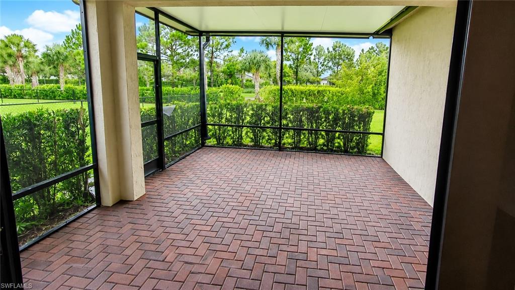 Screened patio with brick paver flooring and lush perimeter landscaping