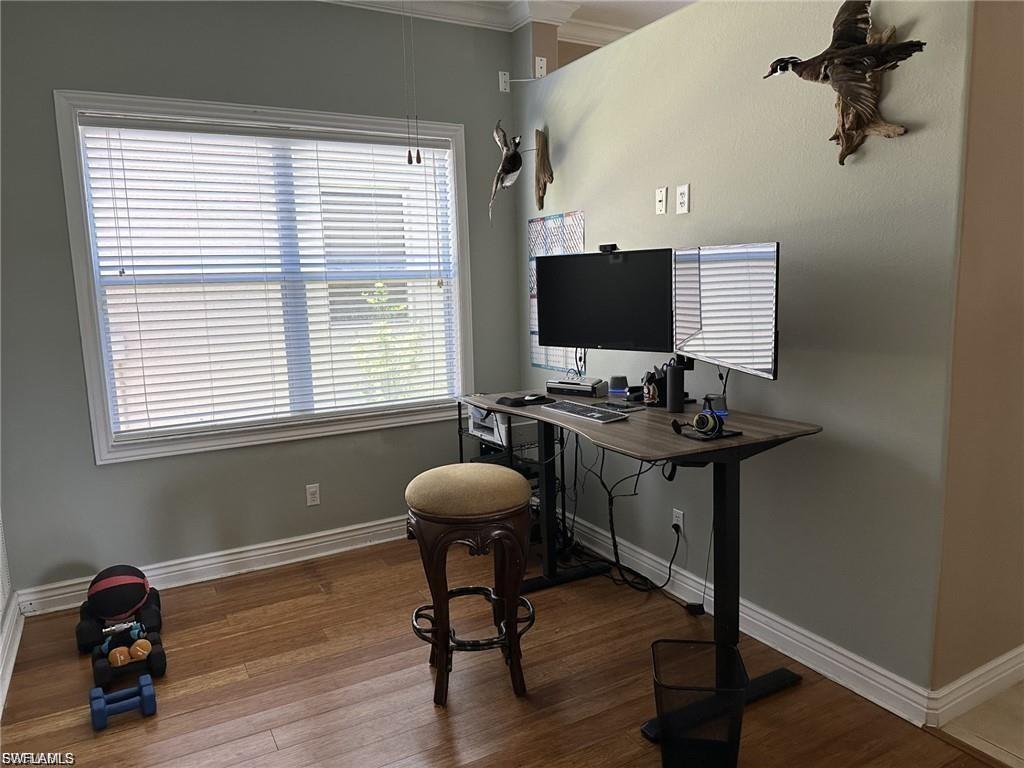 Wood-finish flooring with white trim and window casing