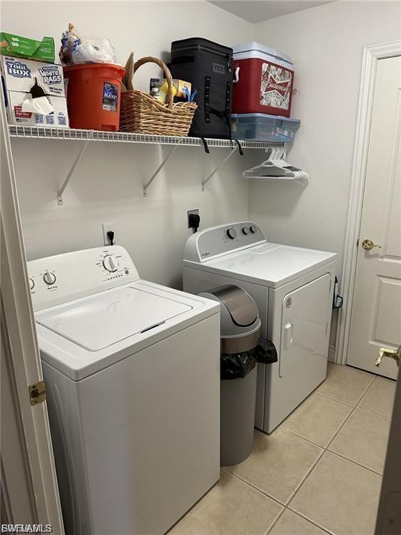 Laundry area featuring a top-load washing machine, front-load dryer, and wall-mounted wire shelving