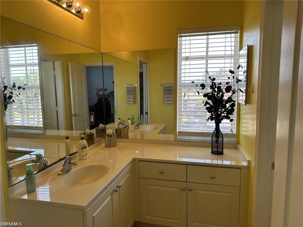 Dual vanity with integrated sinks, light-toned countertops, and white cabinetry