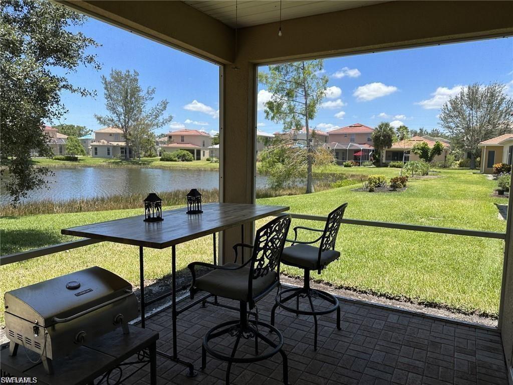 Screened patio with a brick paver floor, overlooking a serene lake and expansive green space