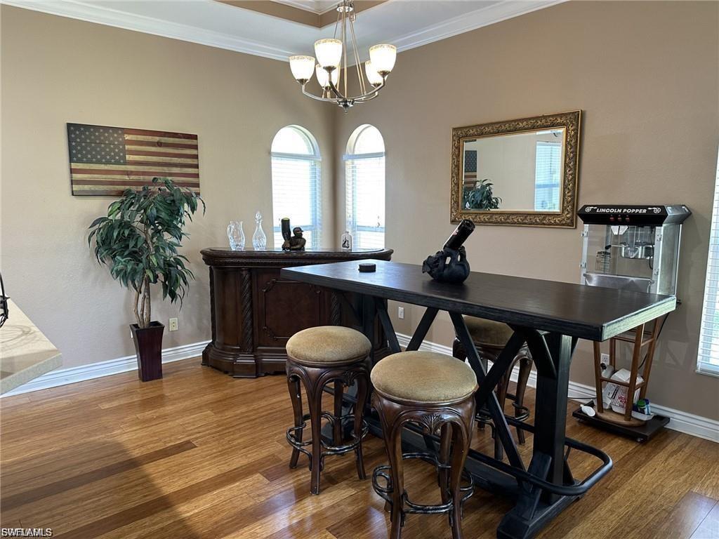 Wood-finish flooring throughout, featuring a coffered ceiling and arched windows