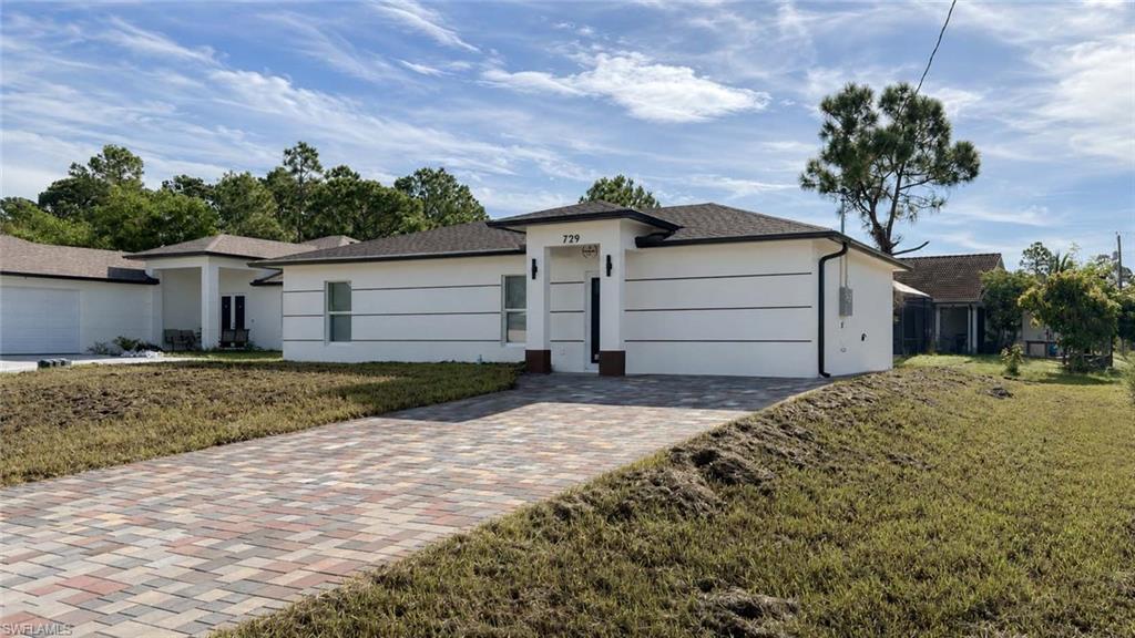 White exterior siding with horizontal banding, dark roof, recessed entry, and exterior lighting fixtures