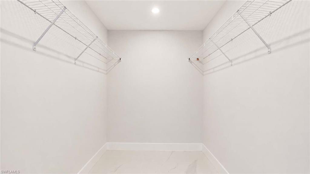 Recessed ceiling light, white painted walls, white wire shelving, tile flooring