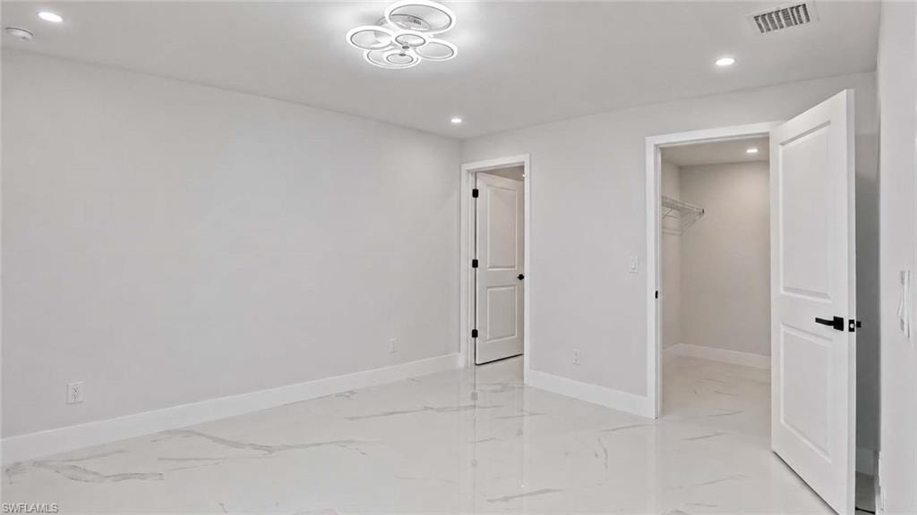 Bright interior featuring tile flooring, white walls, recessed lighting, and a modern ceiling light fixture