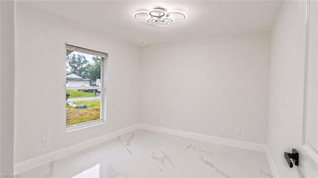 White walls with a single window and a modern ceiling fixture
