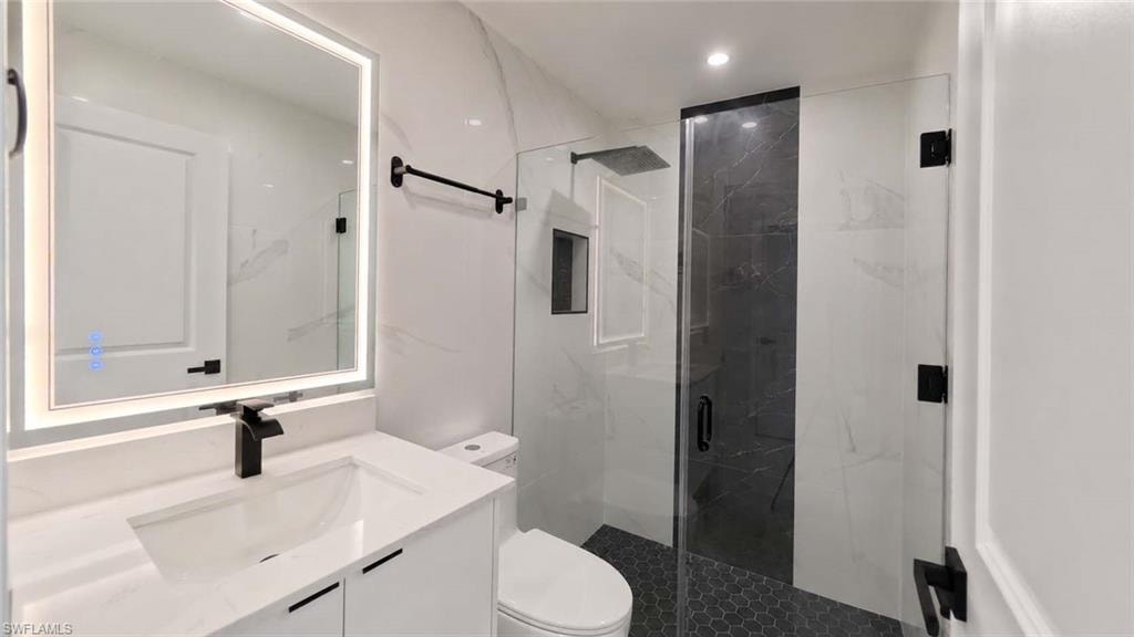 White vanity with under-mount sink, black faucet, and illuminated mirror