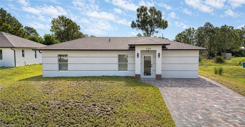 Contemporary exterior with horizontal banding, a paved driveway, and an integrated garage