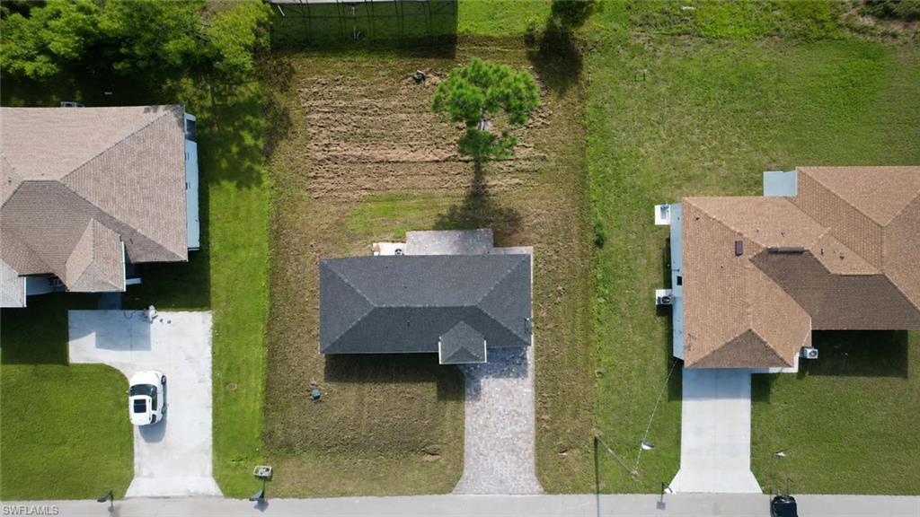 Aerial perspective showcasing multiple properties with paved streets and established landscaping