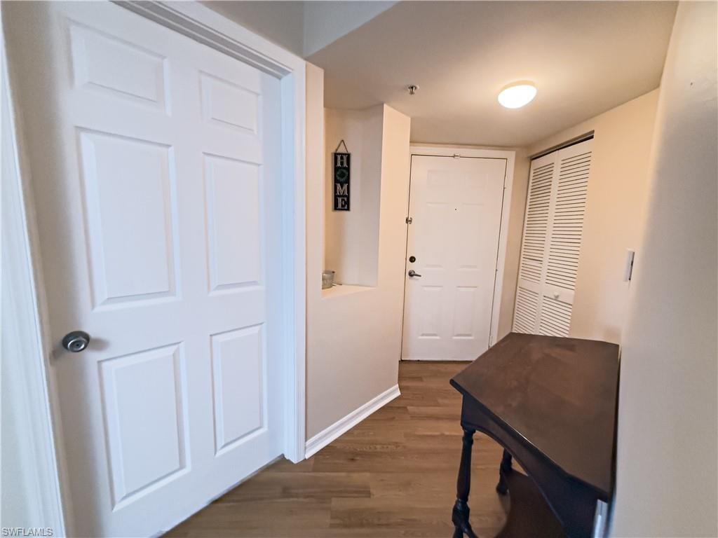Hall featuring dark wood-style floors and baseboards