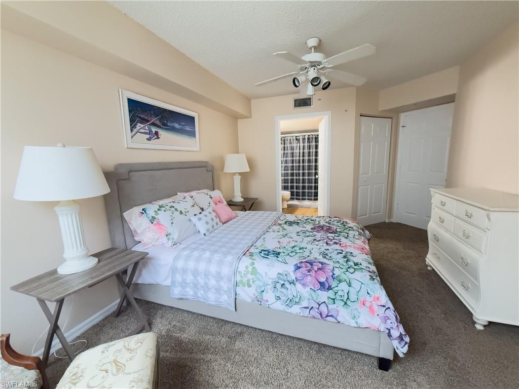 Carpeted bedroom featuring a textured ceiling and a ceiling fan