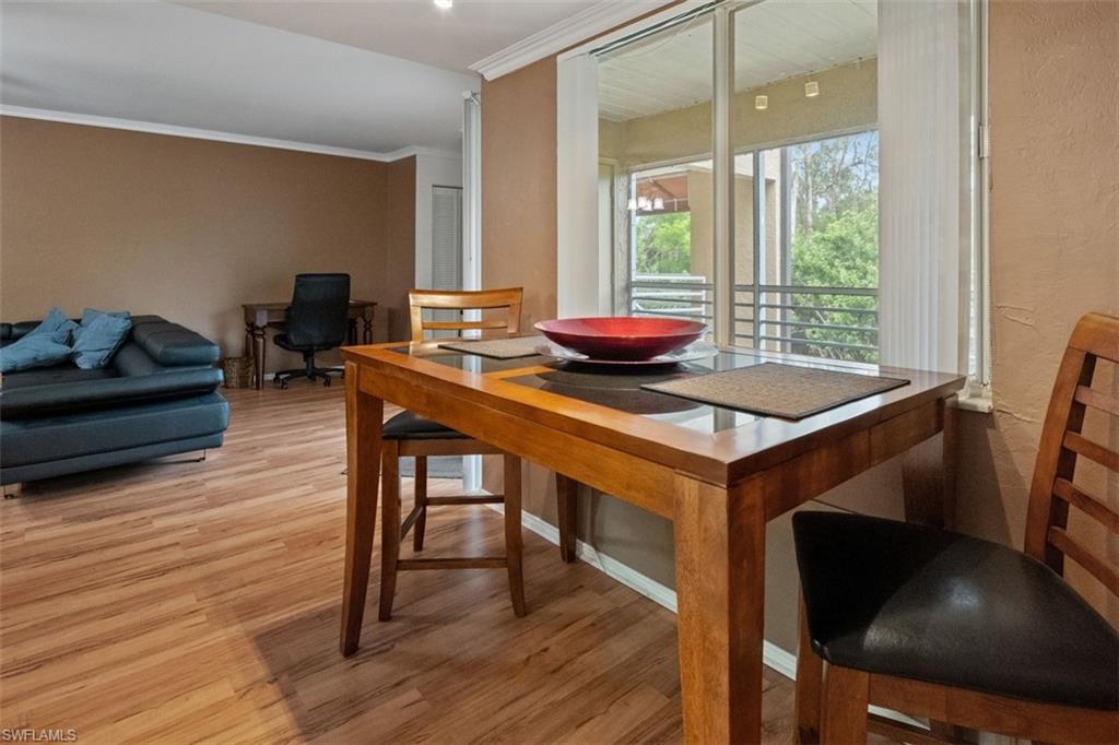Wood-finish flooring throughout, sliding glass door leading to a balcony, and recessed lighting