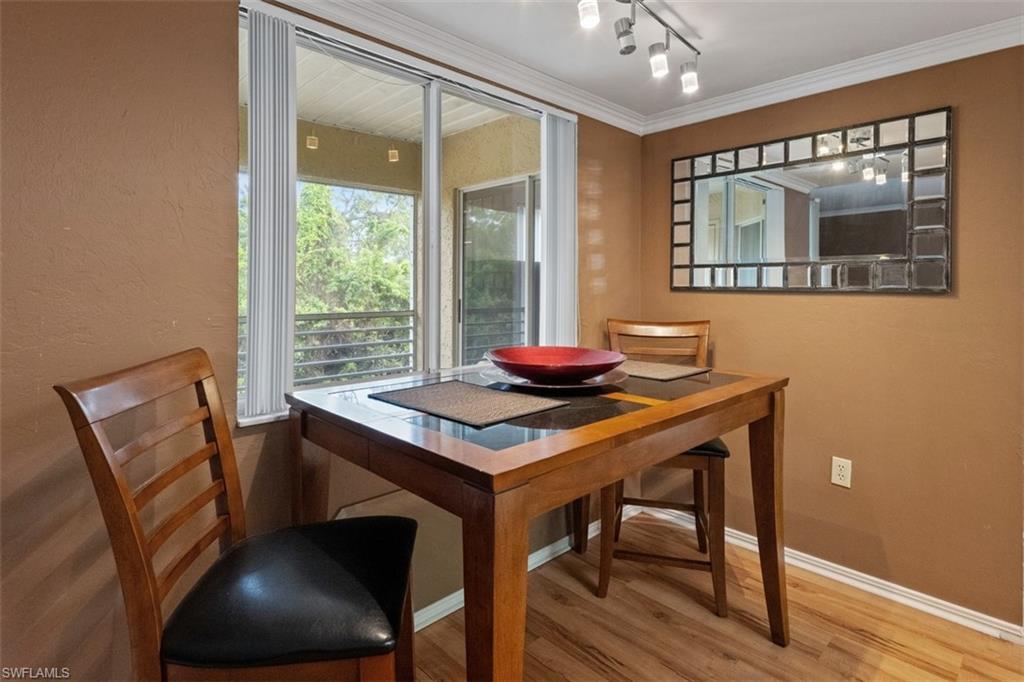 Wood-finish flooring, crown molding, and a sliding glass door