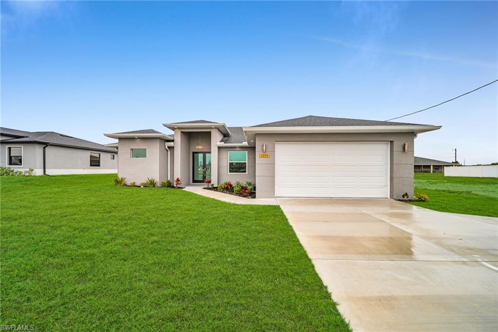 Contemporary-style exterior with a gray facade, an attached garage, a paved driveway, a manicured lawn, and a front entry path