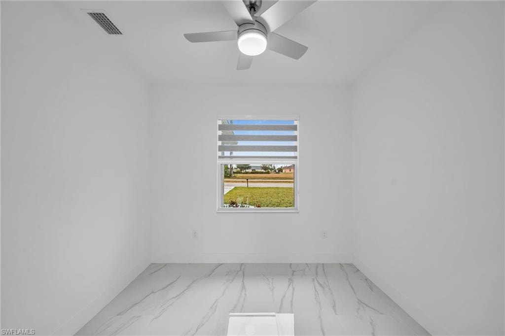 White walls with a window, contemporary ceiling fan, and large format tile flooring