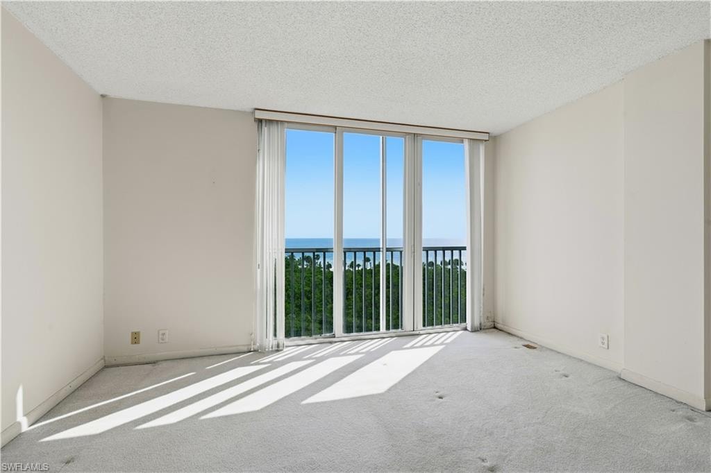 Expansive sliding glass doors with balcony access, offering broad water and tree scenery