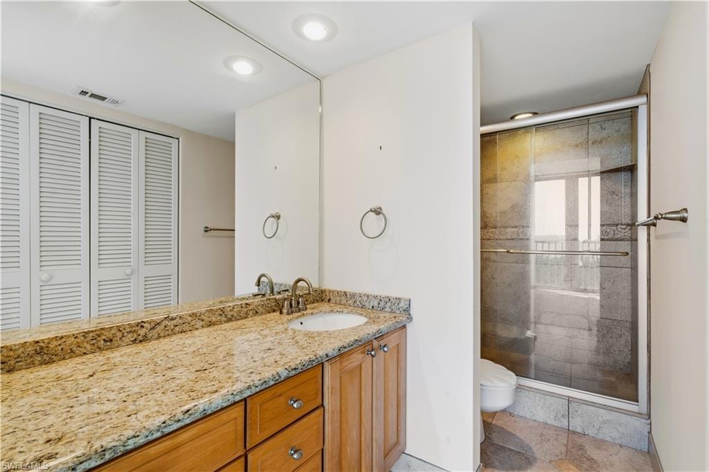 Expansive vanity with a granite countertop, undermount sink, and wood-finish cabinetry
