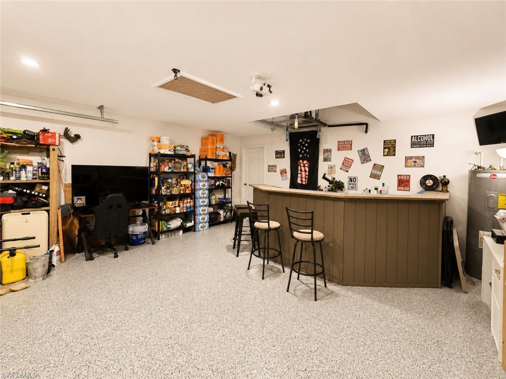 Epoxy-coated flooring, built-in bar, recessed lighting, and white walls